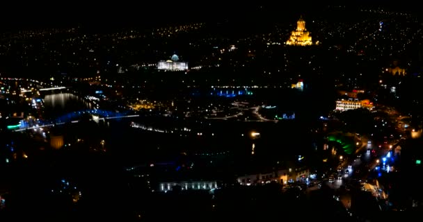 Avond panorama uitzicht op Tbilisi hoofdstad van Georgië land. Metekhi kerk Heilige Drie-eenheid kathedraal Sameba en presidentiële administratie 's nachts met verlichting en bewegende auto' s — Stockvideo