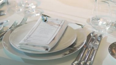 Sofra ziyafet için çatal bıçak, şarap bardağı ve peçeteyle servis edildi. Pastel renkli dekorasyonlar.