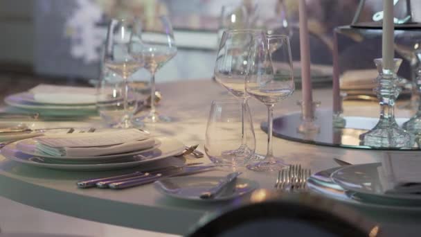 Table de banquet avec couverts, verres à vin et serviettes. Décorations de couleur pastel. — Video