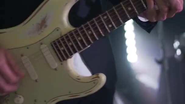 Man in pak speelt zes-snarige elektrische gitaar bij concert. Close-up beelden van muzikanten handen op feest met stroboscoop discolampen. — Stockvideo