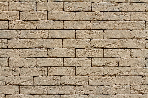 Arka plan, doku olarak sarı kaba tuğla duvar
