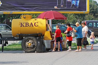 Slutsk, Beyaz Rusya - 10 Ağustos 2013: İnsanlar Kvas Slutsk Caddesi üzerinde sarı bir varil satın