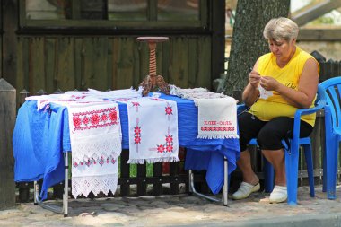 Nesvizh, Beyaz Rusya - 10 Ağustos 2013: Kadın satıcı oturur ve rushnyks Nesvizh Satılık crochets