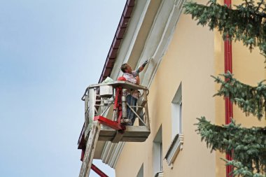Vitebsk, Beyaz Rusya - 05 Ağustos 2013: Vitebsk binanın yüksekliği boyama cephe kova kadında