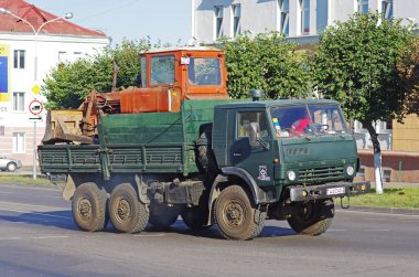 Orsha, Belarus - 16 Ağustos 2013: KAMAZ-4310 Orsha yolunda bir traktör taşıyor