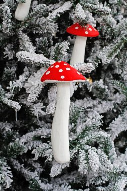 Noel oyuncakları, karda Noel ağacında asılı duran agarikleri uçurur.