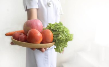 Kadın doktor beslenme uzmanı ile taze elma, domates, havuç, marul el kavramı doğal gıda diyet beslenme ve sağlıklı yaşam