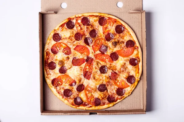 Pizza pereroni in packing box on gray background.