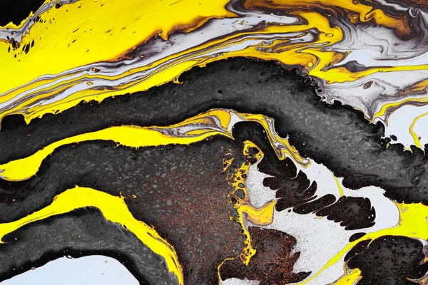 Acrylic Fluid Art. Yellow black waves and gold inclusions. Abstract stone background or texture