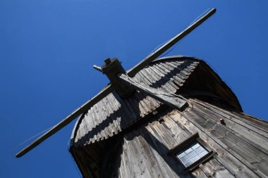 Mavi gökyüzüne karşı eski ahşap yel değirmeni