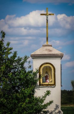 Polonya kırsalındaki eski yol kenarı tapınağı kopya alanı olan bulutlu gökyüzüne karşı