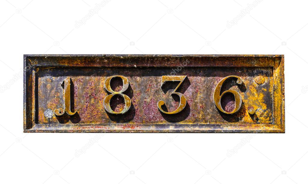 Rusty metal plate with 1836 date of built of old Napoleon fortress on white plaster