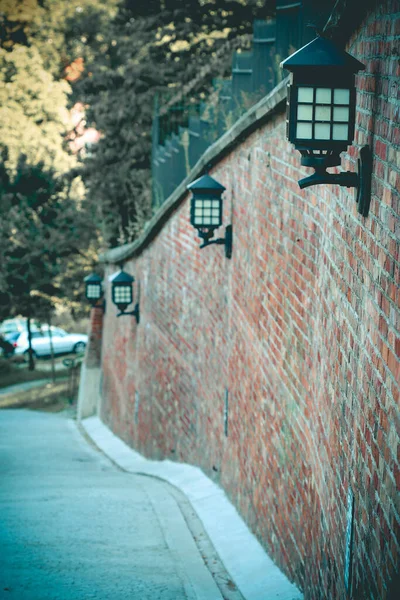 赤レンガの壁に取り付けられた古い鉄塔の行 — ストック写真