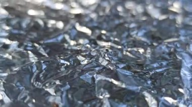 Alüminyum folyo yüzeyinde oluşan güzel bir desen ışığı yansıtıyor ve sanatsal detaylarla parlak metalik bir doku oluşturuyor..