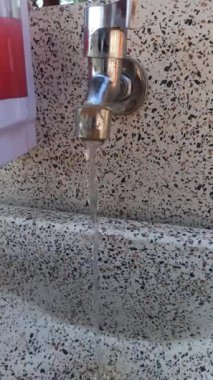 Restoran lavabosundaki su musluğu, temiz ve işlevsel, el ve bulaşıkları yıkamak için kullanılan, hijyen ve pratik mutfak tasarımı yansıtan..