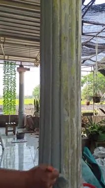 Boyanmakta olan evin ön cephesi, işçilerin ve taze boyanın gösterilmesi, evin yenilenmesini, geliştirilmesini ve dış bakımını sembolize ediyor..