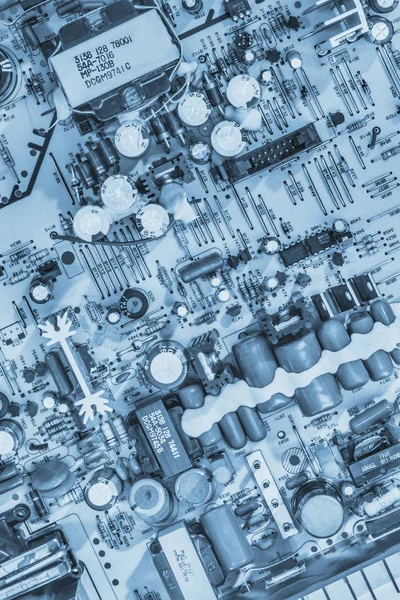 Componentes eletrônicos vintage na placa de circuito fundo azul monocromático — Fotografia de Stock
