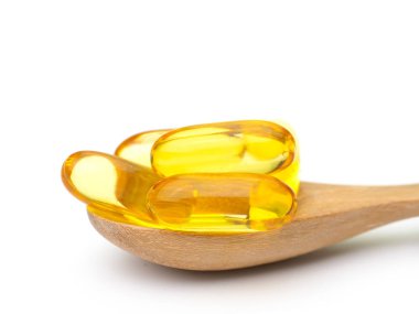 Balık yağı omega 3 jel kapsül, tahta kaşık koymak.