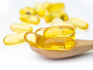 Balık yağı omega 3 jel kapsül, tahta kaşık koymak.