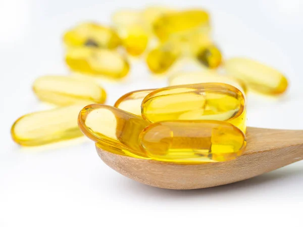 Balık yağı omega 3 jel kapsül, tahta kaşık koymak.