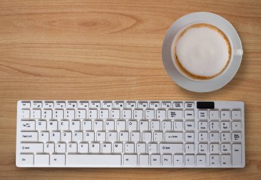  siyah kahve masada bilgisayar klavye ile köpük ile. (İş kavramı