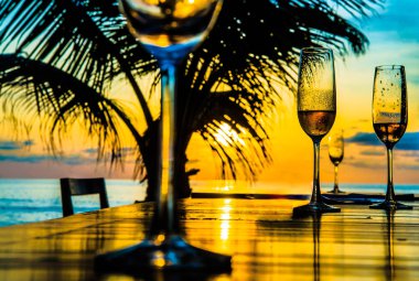 Gözlük günbatımı sarı gökyüzü bulutlu, palm siluet karşı ahşap masa üzerinde arka plan 