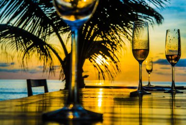 Gözlük günbatımı sarı gökyüzü bulutlu, palm siluet karşı ahşap masa üzerinde arka plan 