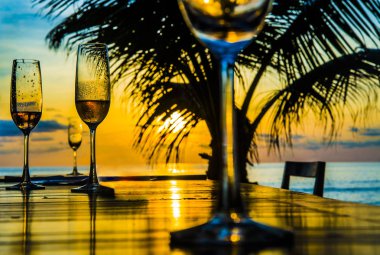 Gözlük günbatımı sarı gökyüzü bulutlu, palm siluet karşı ahşap masa üzerinde arka plan 