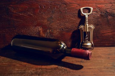 bir şişe şarap ve ahşap arka plan üzerinde metal corkcrew. boş kopya alanı 