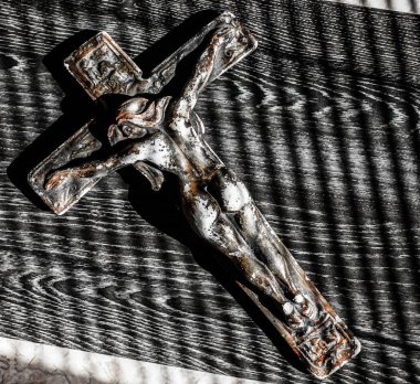 çıplak kadın çarmıhta asılı. güneş ışık ve gölge. ahşap masa veya zemin üzerinde çapraz seramik yaşlı 