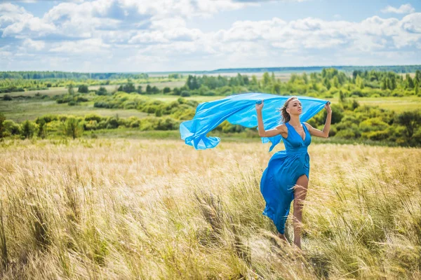 麦畑の上を歩いてロマンチックなスリムな女性の肖像画 彼女は明るいブルーのエレガントなドレスを着ています — ストック写真
