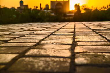 Cobbles at sunset. Sunlight on Cobbled Stones against asian Palace mosque. clipart