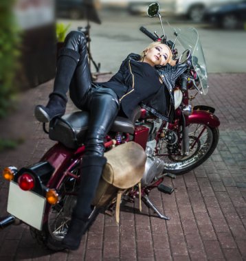 Eski, vintage, retro motosiklet üzerinde yalan deri ceket siyah yüksek Çizmeli sarışın saçlı kadın 