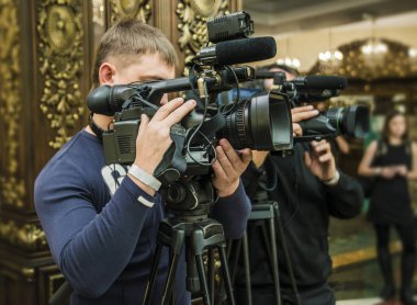 Oda arka plan üzerinde profesyonel video kamera ile operatör.