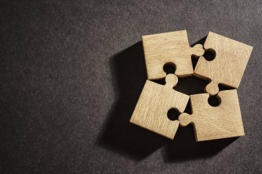 Kağıt arka plan üzerinde dört ahşap puzzle parçaları. bağlantı insanlar kavramı
