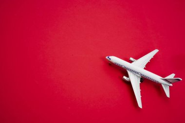 metal oyuncak - kırmızı Kağıt arka plan uçakta. modern uçak izole kırmızı zemin üzerinde. seyahat ve ulaşım fikir.