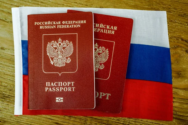 Dois Passaportes Internacionais Russos Sobre Textura Bandeira Russa Mesa Madeira — Fotografia de Stock
