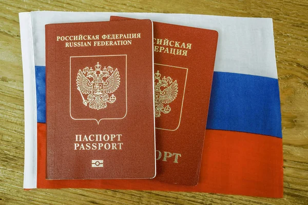 Dois Passaportes Internacionais Russos Sobre Textura Bandeira Russa Mesa Madeira — Fotografia de Stock