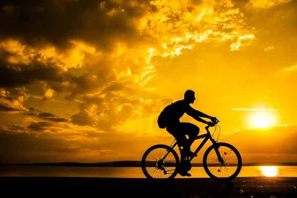 Obraz Człowieka Sportowy Turystyczny Jazda Wzdłuż Brzegu Roweru Przed Zachód — Zdjęcie stockowe