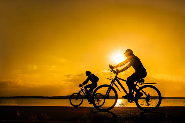 空的空间 运动的朋友在自行车在日落 骑自行车的人沿着海岸 体育在自然背景 — 图库照片