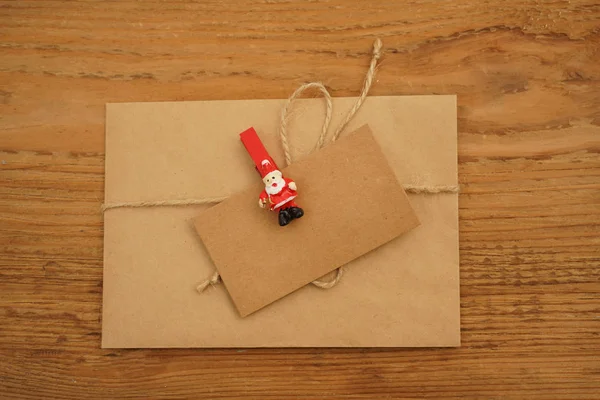 Vintage mail envelope with  card, craft brown paper, pin and rope around. wooden table background.