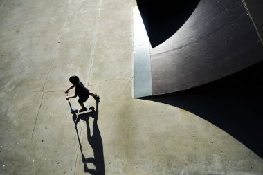 Scooter'a binecek çocuk. Tekme scooter çocuk bir hile yapma ve paten parkta paten tarafından onun sürme zevk