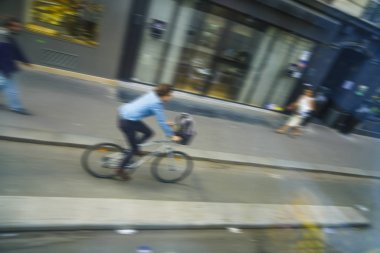 bulanık görüntü. Mutlu genç iş adamı ile sepeti Avrupa şehirde bisiklet sürme