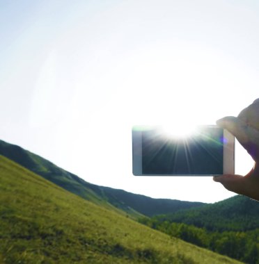 Akıllı telefon ve mavi gökyüzü. erkek eli boş ekranlı akıllı telefon tutarak. 