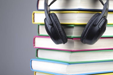 Kitap ve sesli kitaplar kavram olarak kulaklık. gri arka plan üzerinde izole.