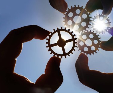  Metal dişliler - gökyüzü arka plan holding eller. iş, etkileşim, ekip çalışması fikir