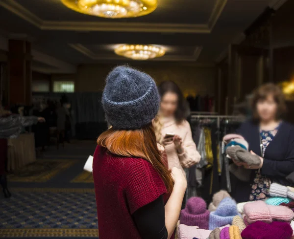 Молодая Рыжая Женщина Пытается Вязать Шляпу Магазине — стоковое фото