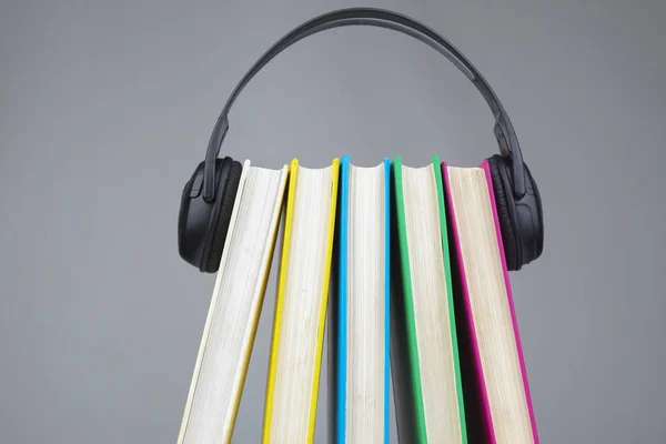 Books and headphones as audio books concept. isolated on grey background