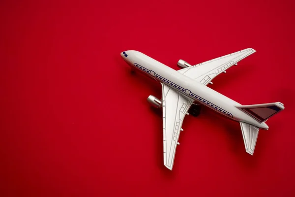 プラスチックのおもちゃ 飛行機 赤い紙の背景に 赤い紙の背景に分離された近代的な旅客機 — ストック写真