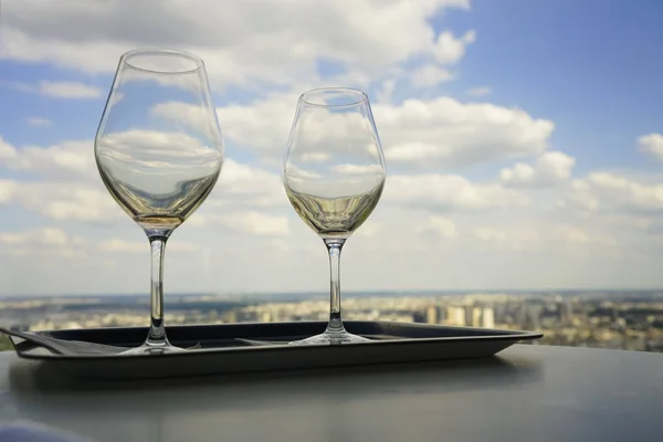 two empty glasses standing on table with city  background